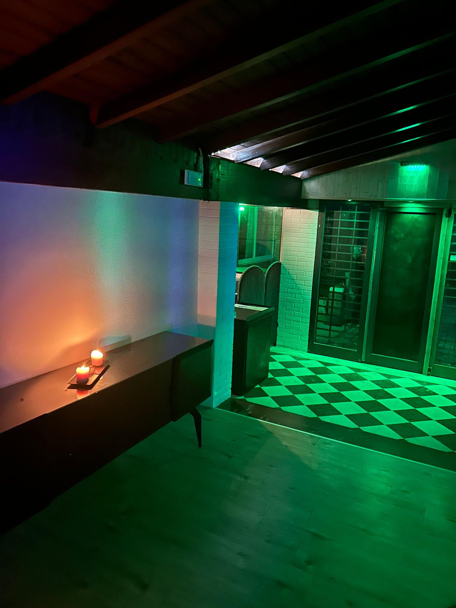 Ingresso con luci verdi e candele Showroom Labs