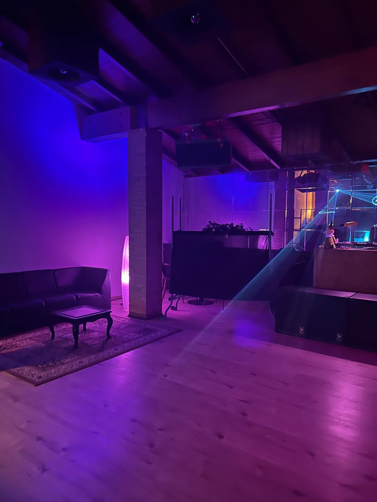 Area lounge con luci viola laser Showroom Labs